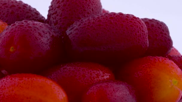 对一堆玛瑙樱桃山茱萸果实与水滴的一面进行宏观射击。在转盘上旋转。在白色背景上被隔离。宏观. — 图库视频影像
