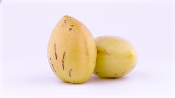 Δύο ολόκληρο ώριμο κίτρινο pepino φρούτα. Περιστρεφόμενη στο πικάπ. Απομονωμένα σε λευκό φόντο. Γκρο πλαν. Μακροεντολή. — Αρχείο Βίντεο