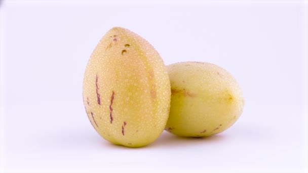 水滴 2 つ全体成熟した黄色いペピーノの果実。ターン テーブルを回転させます。白い背景上に分離。クローズ アップ。マクロ. — ストック動画