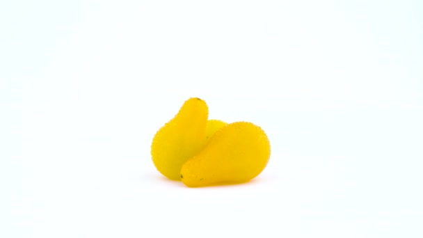 Τρεις μικρές κίτρινες yellow pear ντομάτες με σταγόνες νερό. Περιστρεφόμενη στο πικάπ. Απομονωμένα σε λευκό φόντο. Γκρο πλαν. Μακροεντολή. — Αρχείο Βίντεο