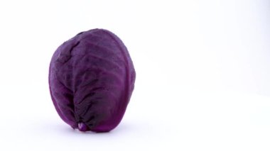 Su damlaları ile bir bütün mini mor lahana yarım çerçeve beyaz arka plan üzerinde izole pikap üzerinde döner. Yakın çekim. Makro.