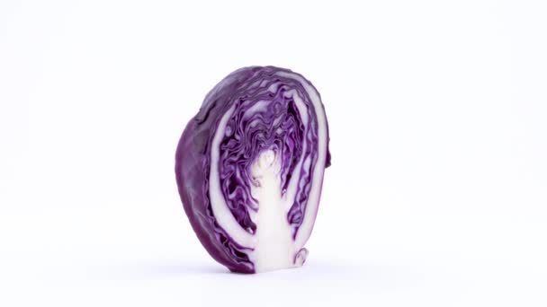 Cross section macro shooting of a half mini purple cabbage with water drops. Slowly rotating on the turntable isolated on the white background. Close-up. — Stock Video