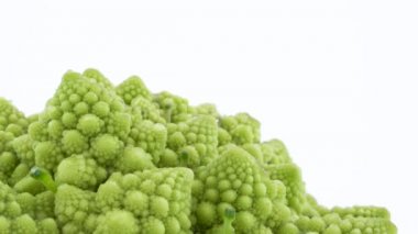 Yakın çekim yan mini romanesco brokoli parçası çekim. Beyaz arka plan üzerinde izole pikap üzerinde yavaş yavaş döner. Yakın çekim.