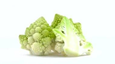 İki bütün ve bir mini romanesco broccolis yarısı beyaz arka plan üzerinde izole pikap üzerinde döner. Yakın çekim. Makro.