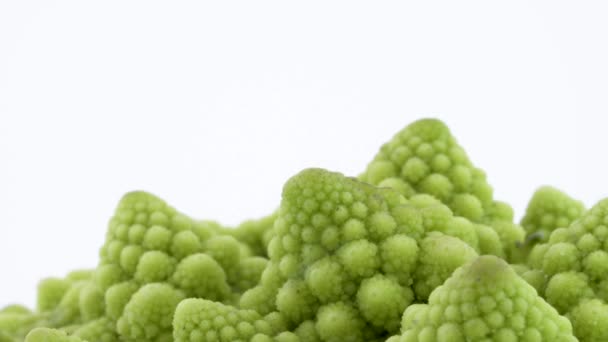 Makro çekim mini romanesco brokoli üst kısmı. Beyaz arka plan üzerinde izole pikap üzerinde yavaş yavaş döner. Yakın çekim. — Stok video