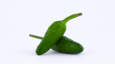 İki küçük yeşil piri-piri chili biber su ile makro çekim bırakır. Turntable döner. Beyaz arka plan üzerinde izole.