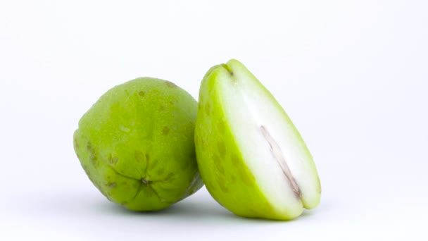 Één geheel en één helft chayote fruit met waterdruppels. Draaien op de draaitafel. Geïsoleerd op de witte achtergrond. Close-up. Macro. — Stockvideo