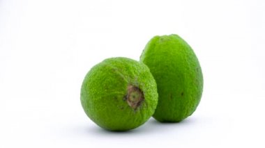 İki tüm elmayı guava meyve su ile bırakır. Beyaz arka plan üzerinde izole pikap üzerinde döner. Yakın çekim. Makro.