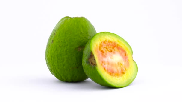 Ένα σύνολο και ένα μισό μήλο φρούτα γκουάβα. Περιστρεφόμενη στο πικάπ απομονώνονται σε λευκό φόντο. Κοντινό πλάνο. Μακροεντολή. — Αρχείο Βίντεο