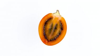 Top üstten görünümünü bir tane yarı olgun tamarillo meyve. Kesit. Beyaz arka plan üzerinde izole pikap üzerinde döner. Yakın çekim. Makro.