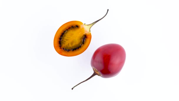 Ovanifrån från ovan av en en och en halv av mogna tamarillo frukter. Roterande på skivtallriken isolerat på den vita bakgrunden. Närbild. Makro. — Stockvideo