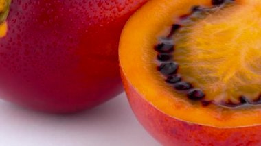 Makro çekim Olgun tamarillo meyve hamuru ikiye ayırmak. Beyaz arka plan üzerinde izole pikap üzerinde yavaş yavaş döner. Yakın çekim.