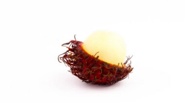Yarısı soyulmuş kırmızı renk rambutan meyve. Beyaz arka plan üzerinde izole pikap üzerinde döner. Yakın çekim. Makro.