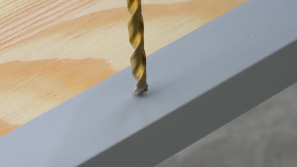 Closeup of a drill bit drilling a hole in the aluminum straight edge profile. Copy space. — Stock Video