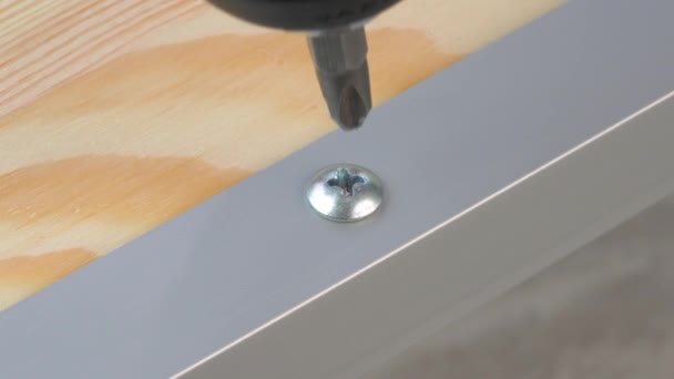 Closeup of electric powered screwdriver unscrewing a self-tapping screw from aluminum profile. Copy space. — Stock Video