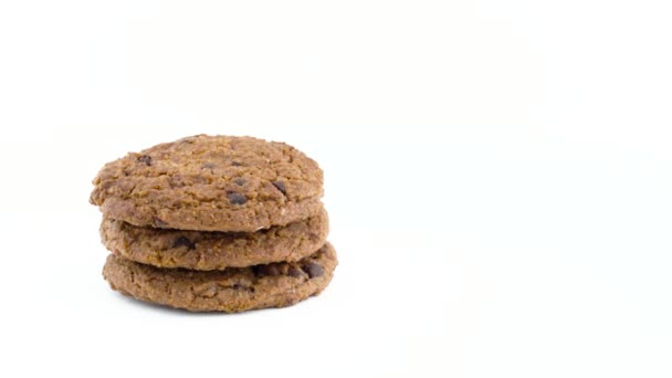 Half frame of a three soft and chewy chocolate chip oatmeal cookies rotating on the turntable. Isolated on the white color background. Close-up. Macro. Copy space. — Stock Video
