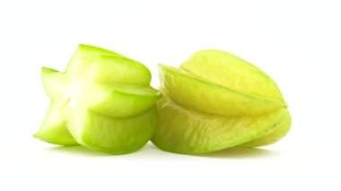 Bir tam ve bir yarım carambola meyve. Beyaz arka plan üzerinde izole pikap üzerinde döner. Yakın çekim. Makro.