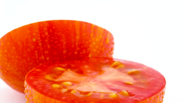 超宏观的半切红地球仪条纹番茄 在白色背景上的转盘上慢慢旋转 — 图库视频影像