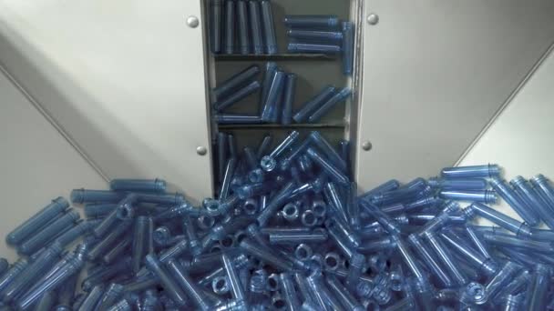 Big pile of small blue blanks lifting up on the factory line to create plastic bottles. — Stock Video