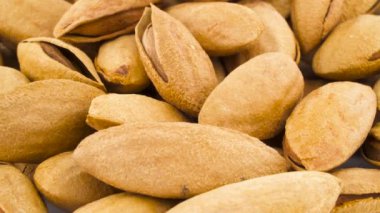 Badem fındık yığını makro çekim. Beyaz arka plan üzerinde izole pikap üzerinde döner. Yakın çekim. Makro. Kopya alanı.