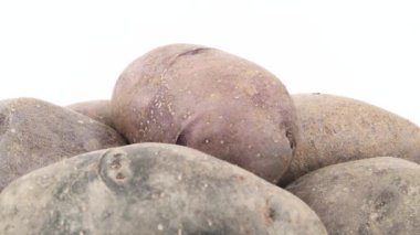 Mor patates yığın üst kısmı makro çekim. Beyaz arka plan üzerinde izole pikap üzerinde yavaş yavaş döner. Yakın çekim.