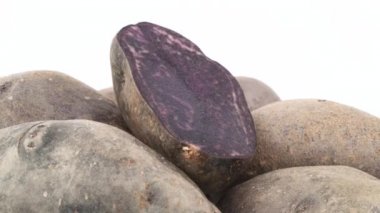 Mor patates üst kısmı makro çekim'kazık ile bir üst yarısı kesilmiş patates. Beyaz arka plan üzerinde izole pikap üzerinde yavaş yavaş döner. Yakın çekim.