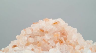 Pembe Himalaya tuz kristalleri. Turntable döner. Gri arka plan üzerinde izole. Yakın çekim. Makro.