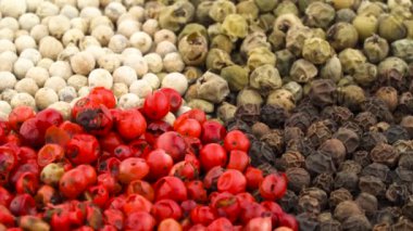Dört renk kuru biber peppercorns karışımı. Beyaz, siyah, yeşil ve pembe. Döner. Yakın çekim. Makro.