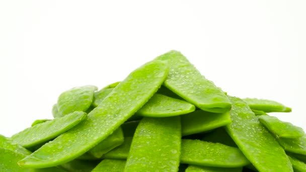 Macro shooting of upper part of snow peas heap. Rotating on the turntable. Isolated on the white background. Close-up. — Stock Video