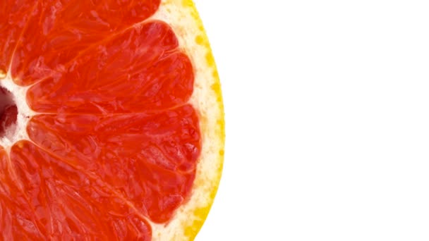 Blick von oben. Die Hälfte des Rahmens einer rosa Grapefruit Querschnitt geschnitten. vertikal rotierend auf der Drehscheibe. isoliert auf weißem Hintergrund. Nahaufnahme. Makro. — Stockvideo