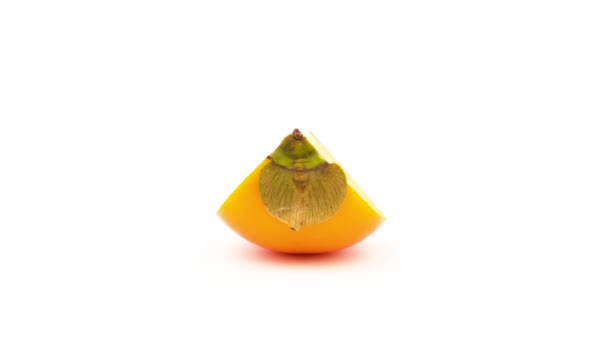 En persimon kaki frukt bit. Roterande på skivtallriken. Isolerad på den vita bakgrunden. Närbild. Makro. — Stockvideo