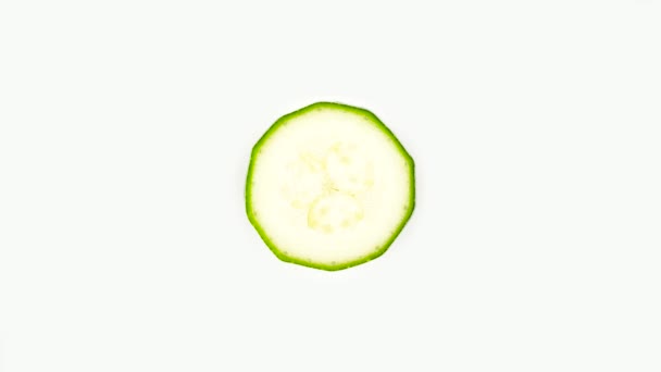 Cross section of a baby green zucchini. Rotating on the turntable. Isolated on the white background. Close-up. Macro. — Stock Video