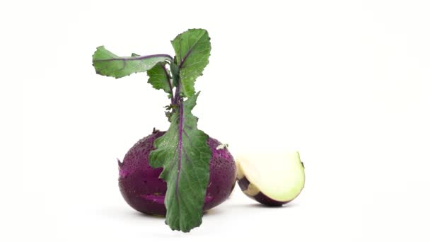 Ein ganzer Kohlrabi-Stiel mit Blättern und wenige Kohlrabi-Stücke mit Wassertropfen. Drehen auf der Drehscheibe. isoliert auf weißem Hintergrund. Nahaufnahme. Makro. — Stockvideo