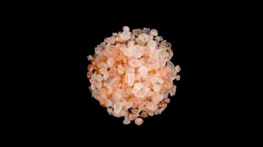 Bir daire üstten üstten görünüm pembe Himalaya tuz kristallerinin yığın şeklinde. Turntable döner. Siyah arka plan üzerine izole. Yakın çekim. Makro.
