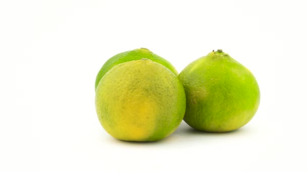 Drie groene tangerine vruchten. Draaien op de draaitafel. Geïsoleerd op de witte achtergrond. Close-up. Macro. — Stockvideo