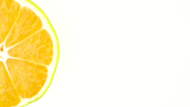 Demi-cadre de section transversale d'une mandarine verte. Rotation sur la plaque tournante. Isolé sur le fond blanc. Gros plan. Macro .