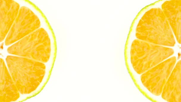 Deux sections transversales d'un fruit vert mandarine tournent dans deux coins du cadre. Isolé sur le fond blanc. Gros plan. Macro .