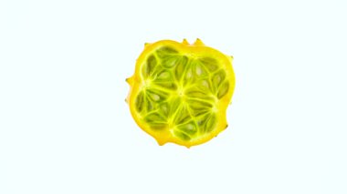 Olgun kiwano bölümü kesim çapraz en iyi görünümü yukarıdaki. Beyaz arka plan üzerinde izole pikap üzerinde yavaş yavaş döner. Yakın çekim. Makro.