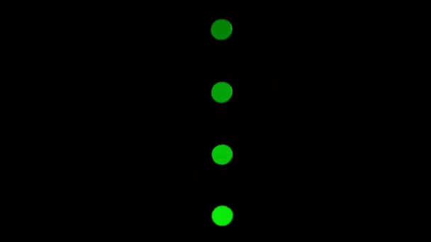 Charging level indicator. Four round green LEDs placed vertically flashing one by one in the dark. Isolated on black. Close-up. Macro. — Stock Video