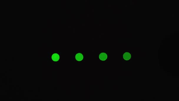 Ladestandsanzeige. vier runde grüne LEDs, die in der Dunkelheit horizontal aufleuchten. isoliert auf schwarz. Nahaufnahme. Makro. — Stockvideo