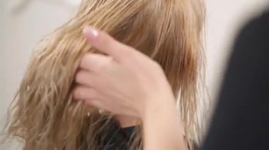 Islak sarı boyalı saç görünümünü yakından. Kuaför el lastik gibi biraz sallamak ve saç kurutma makinesi uzunluğu için kurutma başlar verir. Kamera hareketleri üst takip taşır.
