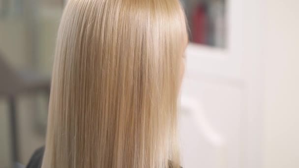 Un gros plan de cheveux blonds teints. La caméra se déplace lentement vers le haut le long des cheveux secs et s'arrête aux extrémités des cheveux . — Video