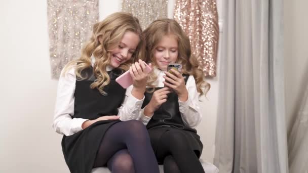 Twee Mooie Meisjes Zitten Bank Binnen Beide Houden Telefoons Kruis — Stockvideo