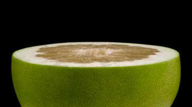 Yarım büyük shaddock pomelo meyve. Dönüş tablo üzerinde döner. Siyah arka plan üzerine izole. Yakın çekim. Makro.