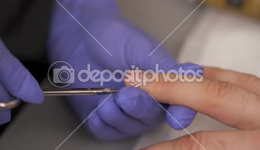 Manikürcü cuticles adam bir tırnak makası kullanarak tırnak kesme Close-up.