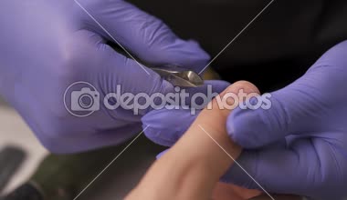 Manikürcü Close-up güzellik salonunda bir makas erkek parmak kullanılarak kütikül keserek eller.