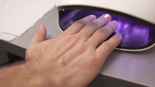 人的手在紫外线干燥灯 指甲上的六带彩虹 Lgbt — 图库视频影像