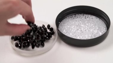 Kristal boncuklar sağa ve siyah iki yuvarlak kapaklı bir closeup dizesini sol boncuklu. Bir kadın eli beyaz kapak siyah bir dize alır ve geri koyuyor