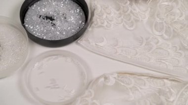 Dikiş beyaz boncuk süslü kumaş onun önünde kapak yuvarlak içinde yatan kadının bir close-up eller
