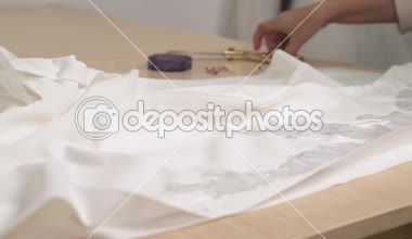 Gelinlik çirkin taraftan kırpmaya bez bir parça kesme ve makas tutan eller bir close-up